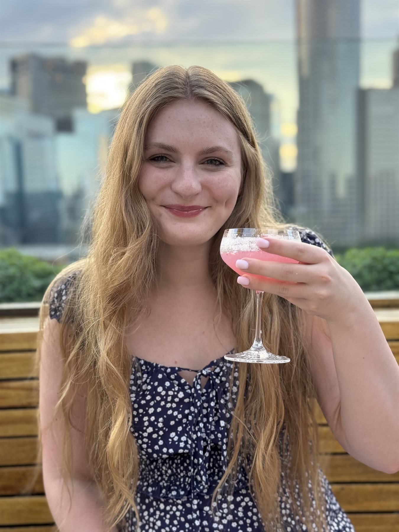 Munchkin smiling with her pink cocktail at Deck 12